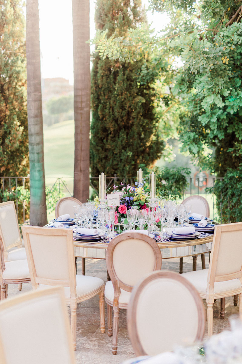 Blue tableware crystal glasses colourful flower arrangements mirror tables wedding Anantara Villa Padierna